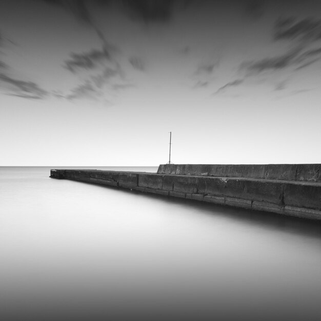 Molo in mezzo al mare contro il cielo durante il tempo nebbioso