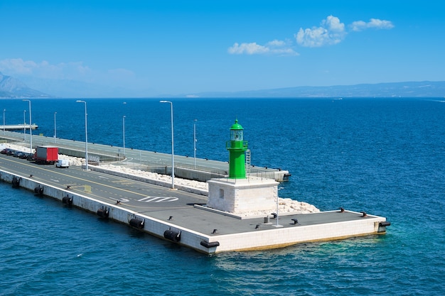 Molo moderno in cemento con poche auto e faro luminoso di colore verde, area portuale di Spalato sul mare Adriatico.