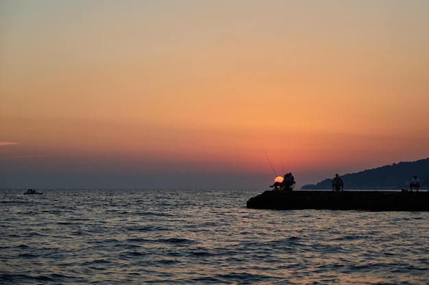 Molo sul mare al tramonto dove i pescatori pescano