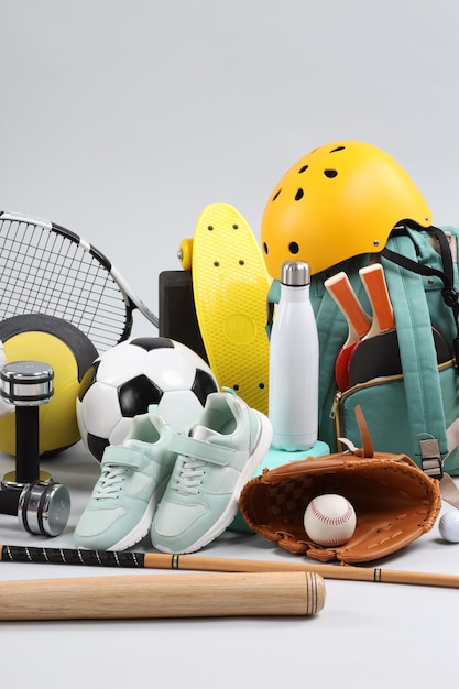 Molte attrezzature sportive diverse su uno sfondo grigio chiaro