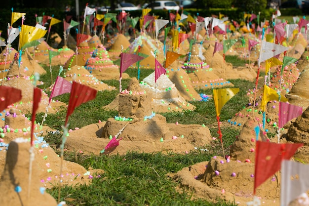 Molte bandiere di carta mettono in un mucchio di sabbia per celebrare un tempio Songkran Festival in Thailandia