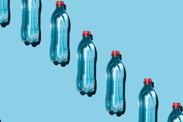 Molte bottiglie d'acqua di plastica su sfondo blu