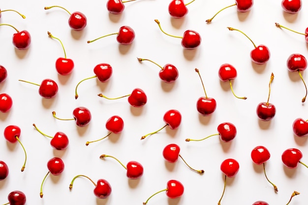 Molte ciliegie rosse su sfondo bianco