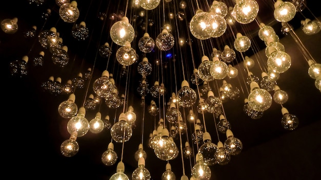 Molte lampadine che scendono con i loro cavi dal soffitto creando un'illusione ottica unica.