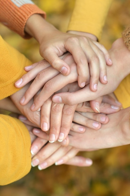 Molte mani unite sul primo piano di sfondo autunnale