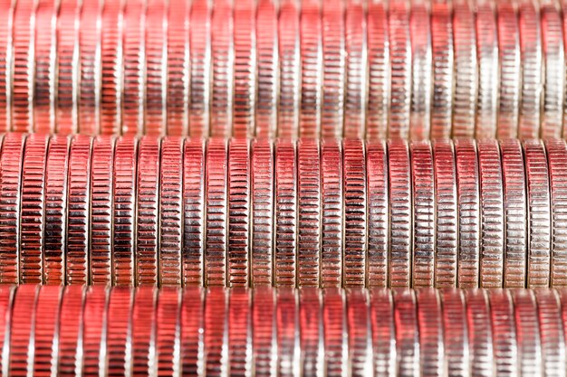 Molte monete metalliche rotonde di colore argento illuminate in rosso, moneta a corso legale utilizzata per i pagamenti nello stato, bellissime monete in primo piano con una tonalità rossa dello stesso valore della moneta