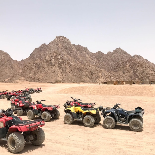 Molte motociclette ATV a quattro ruote motrici potenti e potenti a quattro ruote motrici nel caldo deserto sabbioso