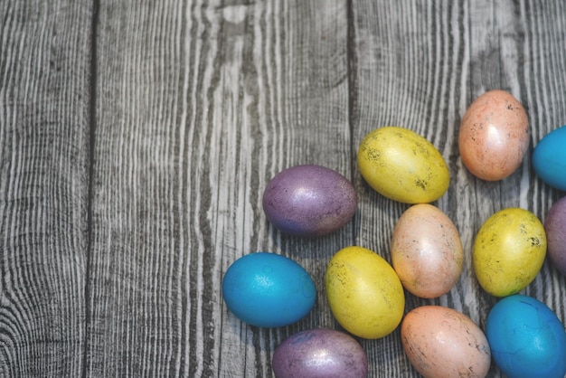 Molte multi uova di pasqua colorate sullo sfondo di legno