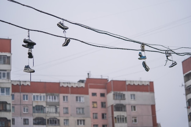 Molte paia di scarpe pendono in alto sui fili tra le case