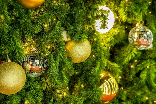 Molte palle di Natale dorate hanno decorato l'albero di pino il giorno di Natale.