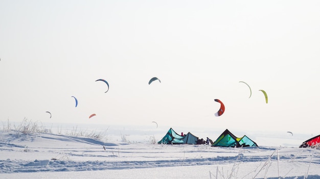 Molte persone fanno snowkite Paracadutismo su terreni innevati Tende invernali