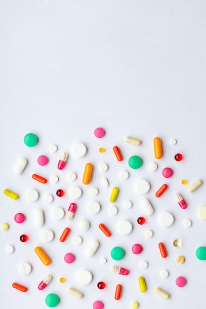 Molte pillole diverse su sfondo bianco piatto layGlobal Industria farmaceutica e prodotti medicinali Pillole colorate Compresse e capsule concetto di medicina e farmaco