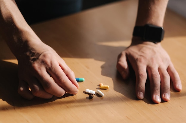 Molte pillole multicolori sulle mani del maschio Uomo con orologio a portata di mano Concetto di coronavirus