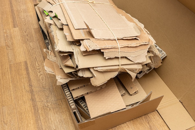 Molte scatole di cartone strappate assemblate in un fascio, impilate per il riciclaggio