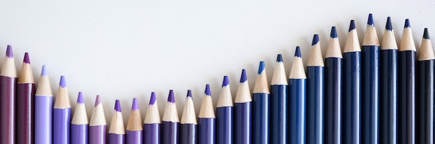 Molte sfumature di matite blu e viola che si trovano sul primo piano bianco del fondo