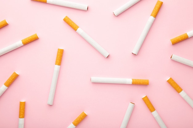 Molte sigarette sulla vista superiore della superficie rosa