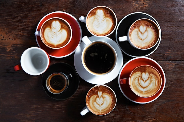 Molte tazze di caffè sulla tavola di legno, vista dall&#39;alto