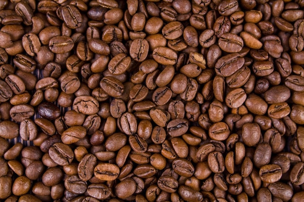 Molti chicchi di caffè tostati giacciono insieme