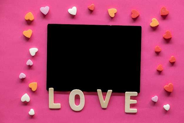 molti cuori con la parola amore su sfondo rosa, icona di amore, San Valentino, concetto di relazioni
