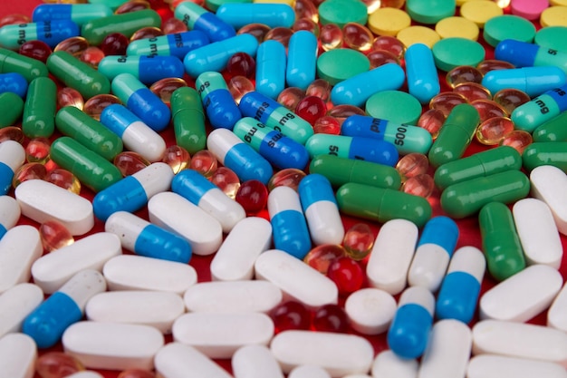Molti diversi farmaci colorati e pile di pillole di vari farmaci multicolori