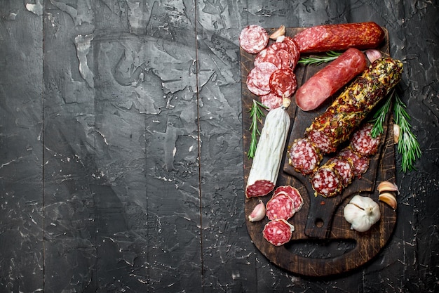 Molti diversi tipi di salame su tavola di legno