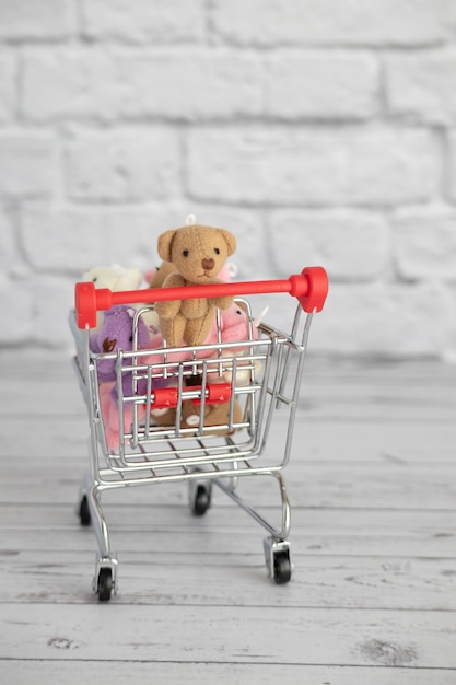 Molti giocattoli colorati orsacchiotti giacciono nel carrello della spesa. Fare la spesa al mercato. Acquisto di regali per compleanni e feste.