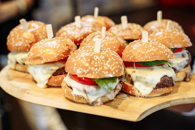 Molti gustosi hamburger sul tavolo di legno