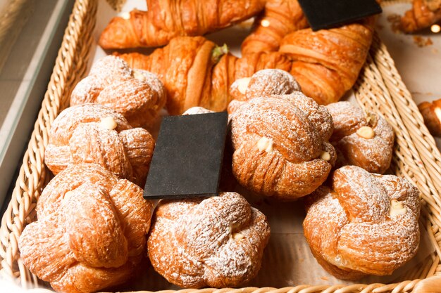 Molti panini e cornetti su uno scaffale di una pasticceria