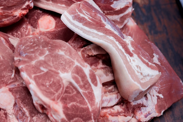 Molti pezzi di carne di maiale fresca su un tagliere di legno