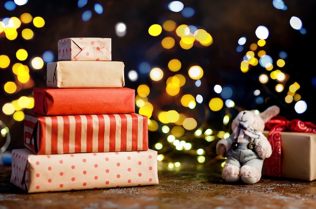 Molti regali in carta da regalo e casa di marzapane fatta in casa, luci bokeh