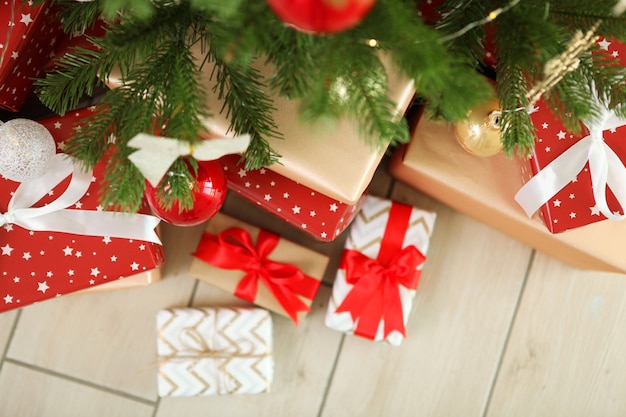 Molti regali sotto un albero di Natale decorato a festa in un interno luminoso