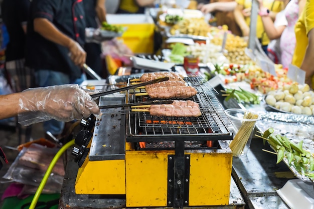 Molti spiedini di carne kebab nel mercato notturno vietnamita nel processo di cottura del festival alimentare