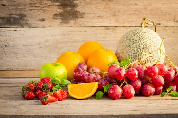 Molti tipi di frutta collocati su un pavimento di legno.