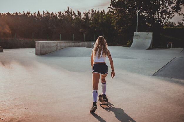 Momenti di lifestyle di bella ragazza skater in uno skatepark