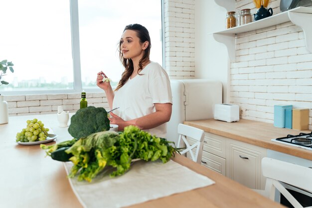 Momenti di stile di vita di una giovane donna a casa. Donna che prepara un'insalata in cucina