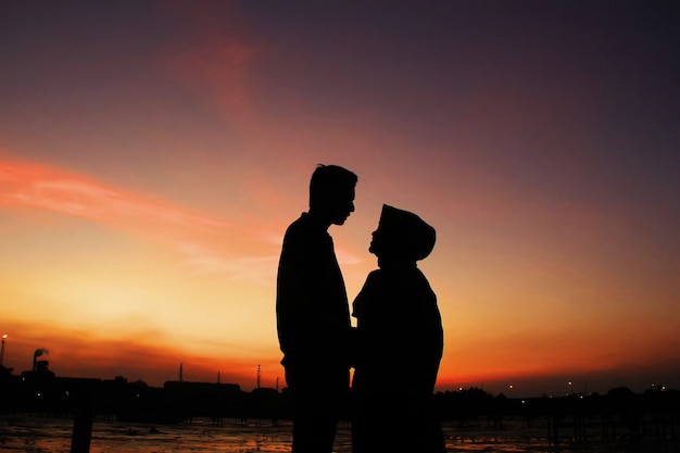 Momenti romantici di due coppie sotto il cielo con il tramonto