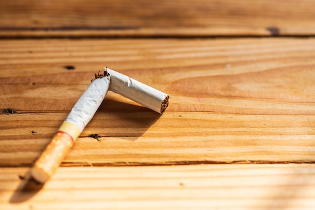 Mondo nessun giorno del tabacco, Chiuda sulla sigaretta rotta sul fondo di legno della tavola.