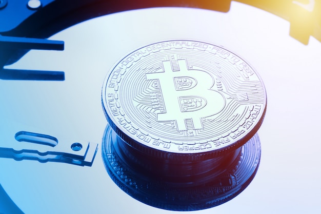 Moneta bitcoin d'argento sulla piastra del disco rigido del disco rigido.