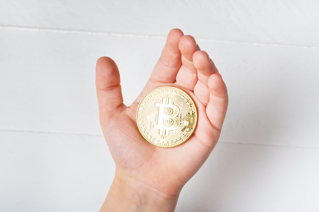 Moneta Bitcoin in mano a un bambino. Avvicinamento.
