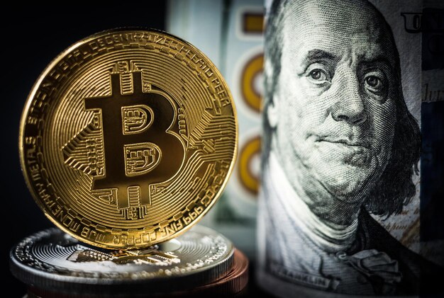 Moneta Bitcoin in piedi davanti alle banconote da un dollaro