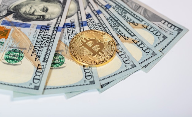 Moneta d'oro Bitcoin o BTC con segno di criptovaluta sulle banconote del dollaro americano