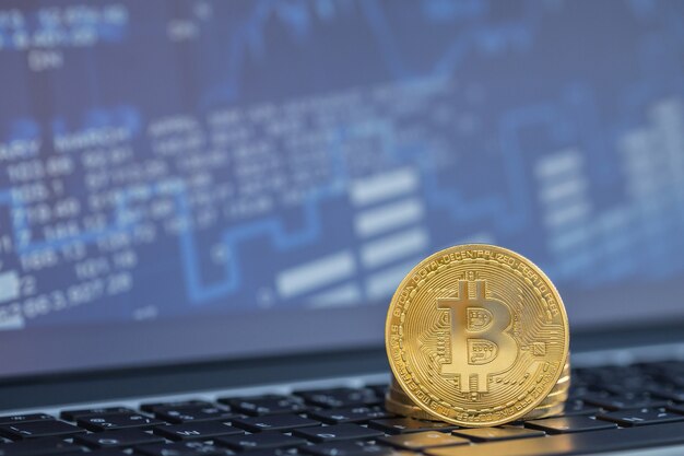 Moneta d&#39;oro con simbolo bitcoin sul computer portatile