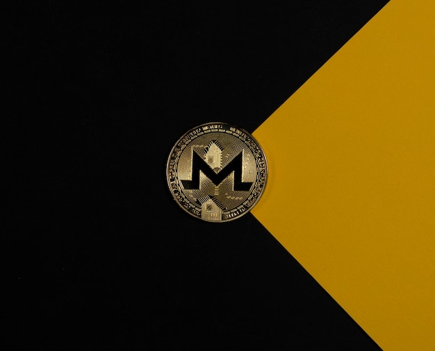 Moneta d'oro Monero su sfondo nero e giallo come criptovaluta a busta e investimento crittografico