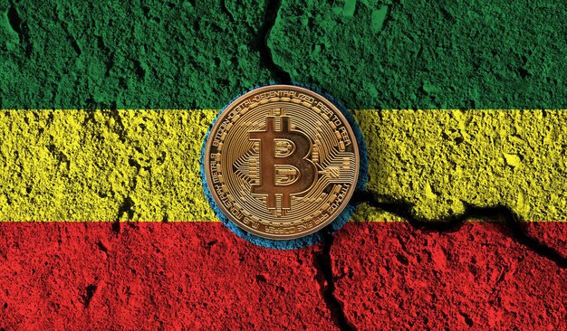 Moneta di criptovaluta Bitcoin con restrizioni crittografiche della bandiera dell'Etiopia incrinate