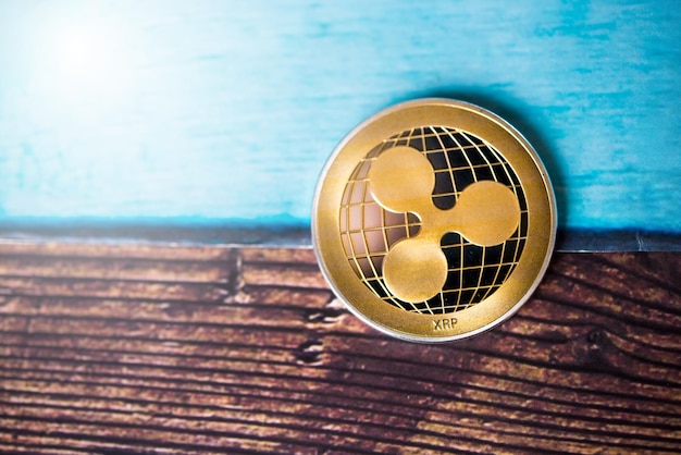 Moneta di criptovaluta Golden Ripple XRP su sfondo di legno scuro