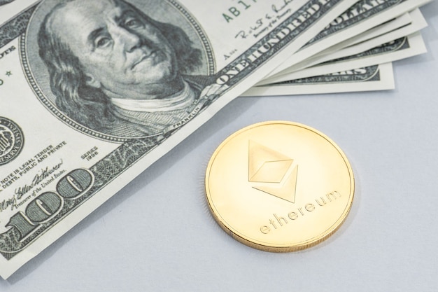 Moneta di Ethereum e una pila di banconote in dollari USA. Denaro blockchain contro concetto di denaro fiat