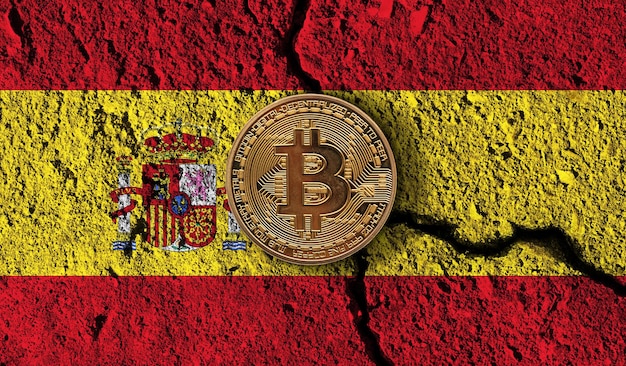 Moneta in criptovaluta Bitcoin con restrizioni crittografiche della bandiera della Spagna incrinate