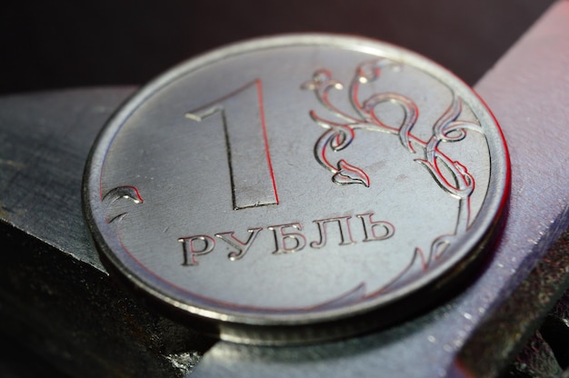 Moneta russa da un rublo sullo sfondo di una chiave inglese. avvicinamento.