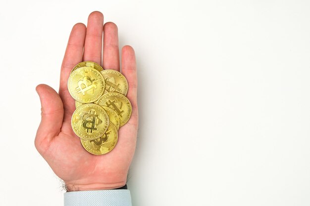 Monete bitcoin d'oro nel concetto di pagamento di valuta crittografica mano dell'uomo