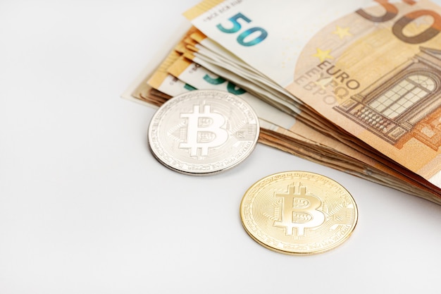 Monete Bitcoin e banconote in euro. Criptovaluta contro il concetto di denaro fiat